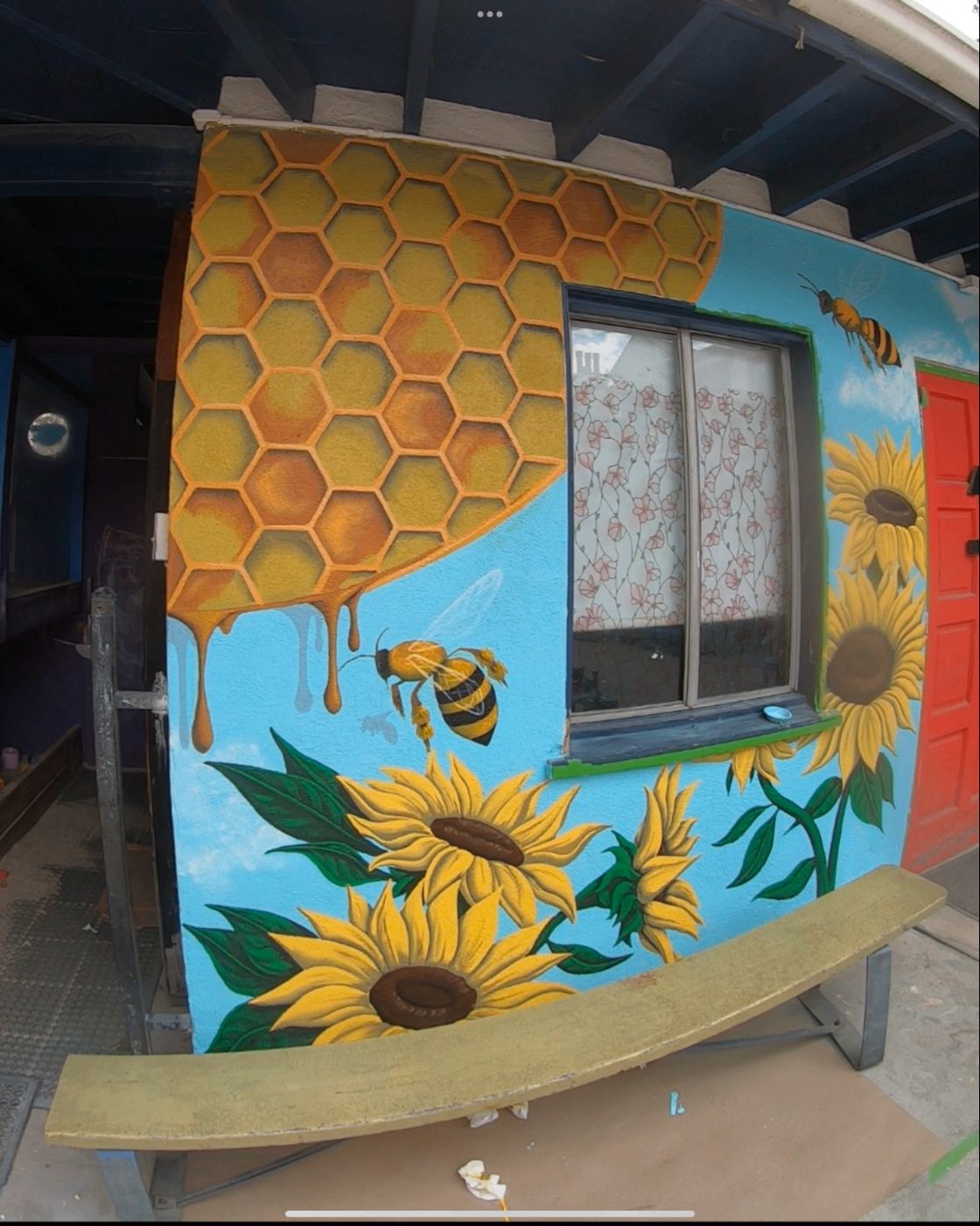 Honeycomb, bees and sunflowers mural on a house exterior
