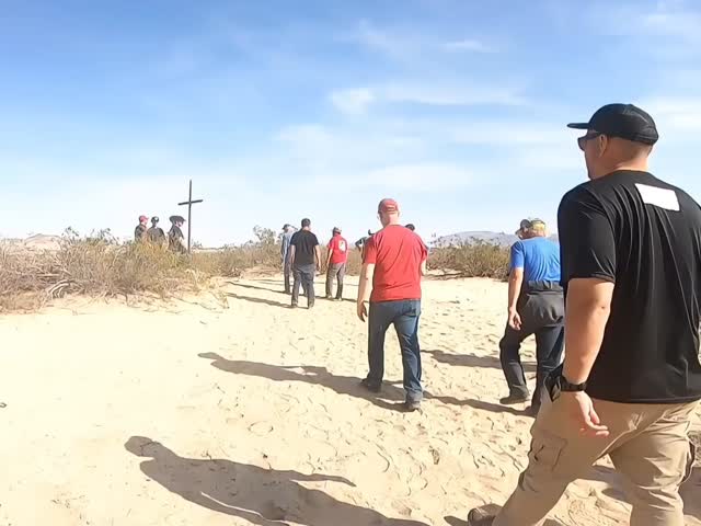 People walking toward a cross in the desert