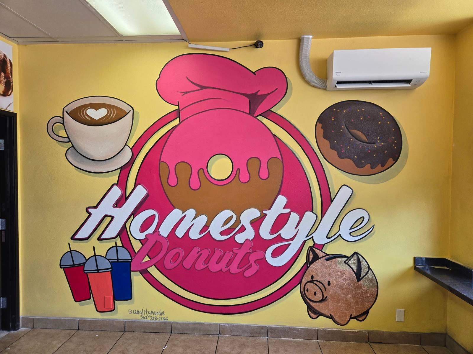 Homestyle Donuts mural with a pink donut chef logo, coffee cup and piggy bank